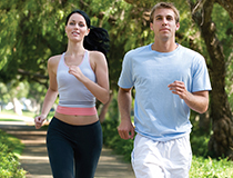 man and women jogging in park